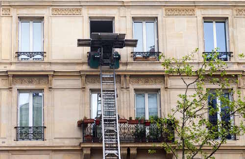 Außenfassade eines Mehrfamilienhauses. Vor dem Haus steht ein Möbellift. Als Umzugsunternehmen aus Hamburg unterstützen wir Sie bei Ihrem Privatumzug.